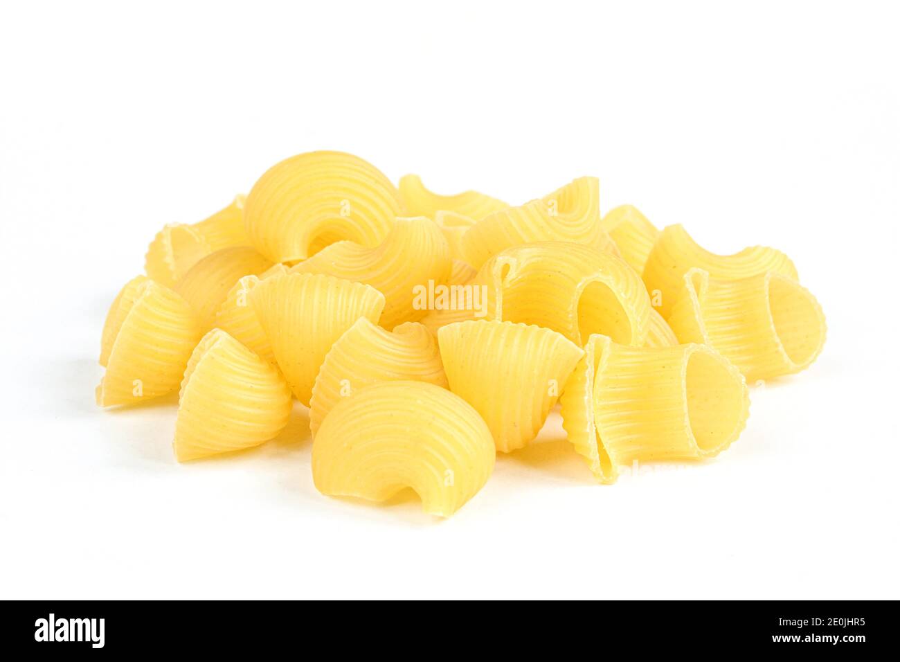 Porzione di lumache di pasta non cotte isolate su sfondo bianco. Piatto rigato italiano secco Foto Stock