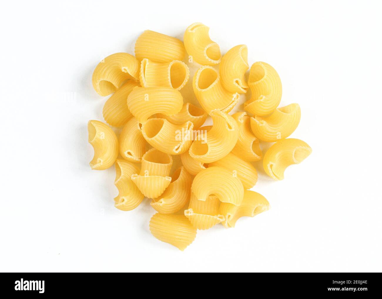 Porzione di lumache di pasta non cotte isolate su sfondo bianco. Piatto rigato italiano secco Foto Stock