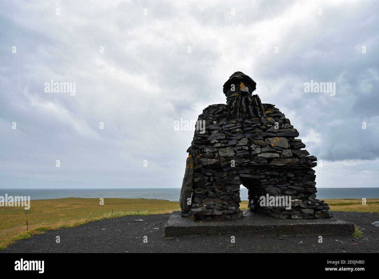 La grande struttura in pietra di Bárður Snæfellsás lungo la costa di Arnarstapi sulla penisola di Snaefellsnes in Islanda occidentale. Foto Stock