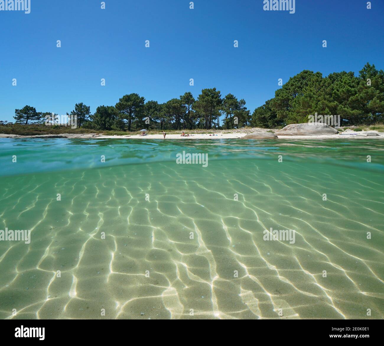 Spagna Galizia, spiaggia costa in estate e sabbia sott'acqua, oceano Atlantico, vista split sopra e sotto la superficie d'acqua, provincia di Pontevedra Foto Stock