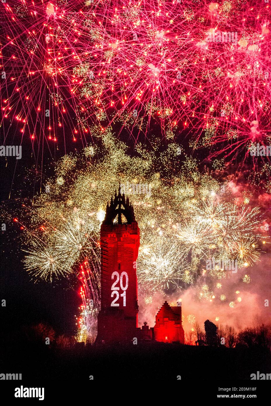 Stirling, Scozia, Regno Unito. 1 gennaio 2021. Nella foto: Hogmanay pirotecnico spettacolare chiude fuori 2020 e porta nel 2021 con un colpo come esplosioni colorate scoppiare illuminando il nuovo anno cielo notte 600 piedi sopra il monumento Wallace a Stirling. A causa della pandemia del coronavirus (COVID19), lo spettacolo sarà trasmesso in diretta in TV e online dal momento che la Scozia è nella fase 4 di blocco. Edinburgh based Events Company, 21CC Events Ltd, specialisti pirotecnici hanno trascorso gli ultimi giorni a organizzare lo spettacolo, tra cui potenti luci di proiezione per la facciata monumenti. Credit: Colin Fisher/Alamy Live News. Foto Stock