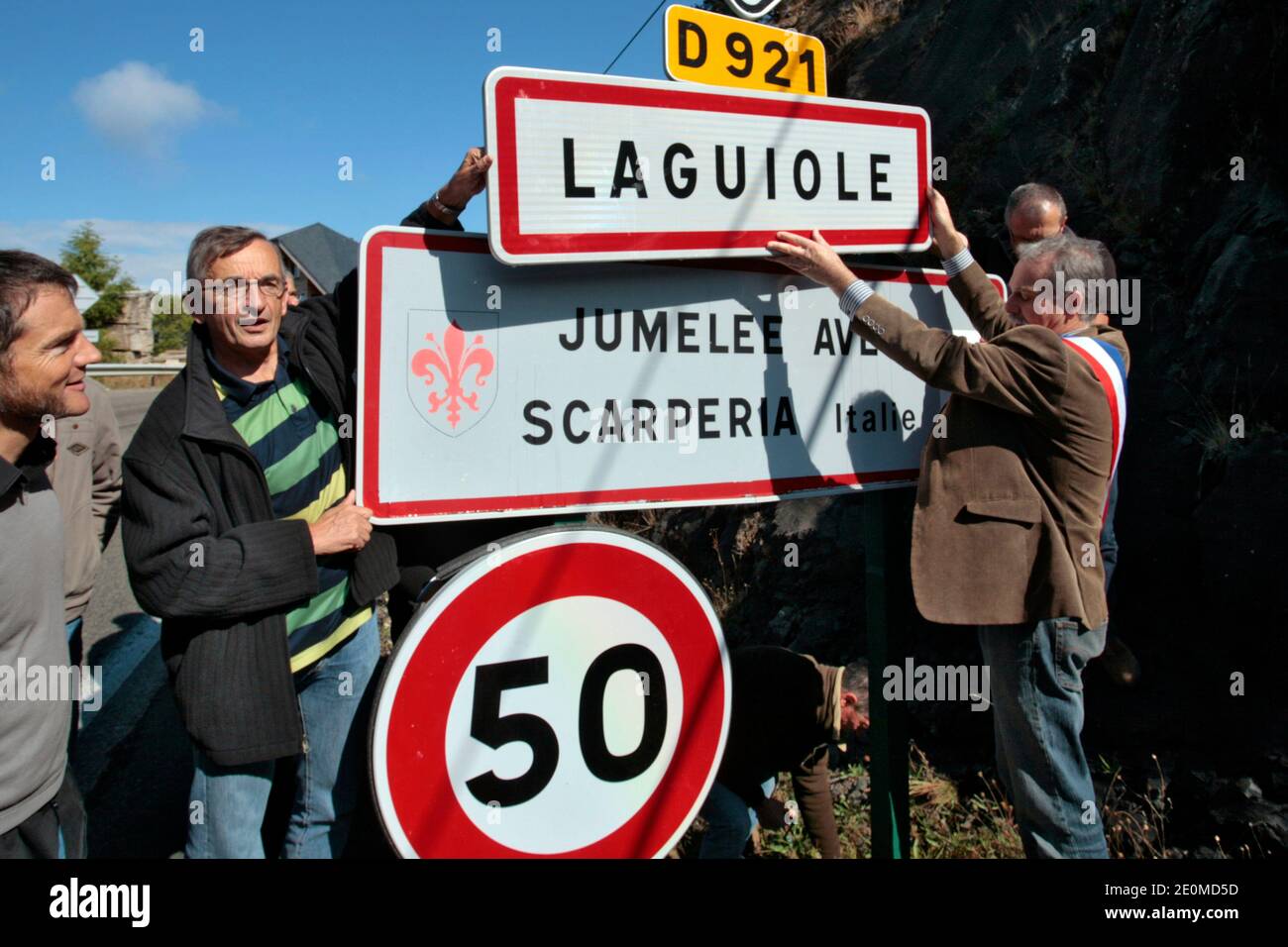 Lo chef francese Michel Bras (L) e il sindaco locale, Vincent Alazard, rimuovono un cartello stradale che legge il nome del villaggio il 19 settembre 2012 a Laguiole, Francia centrale. I residenti di Laguiole, un villaggio sinonimo dei coltelli più famosi della Francia, hanno simbolicamente 'senza nome' la loro casa in una protesta per aver perso il controllo sul nome. Gli abitanti del villaggio sono furiosi che il nome Laguiole è passato nelle mani di un imprenditore che gli permette di essere utilizzato per vendere coltelli made-in-China e barbecue. Foto di Pascal Parrot/ABACAPRESS.COM Foto Stock