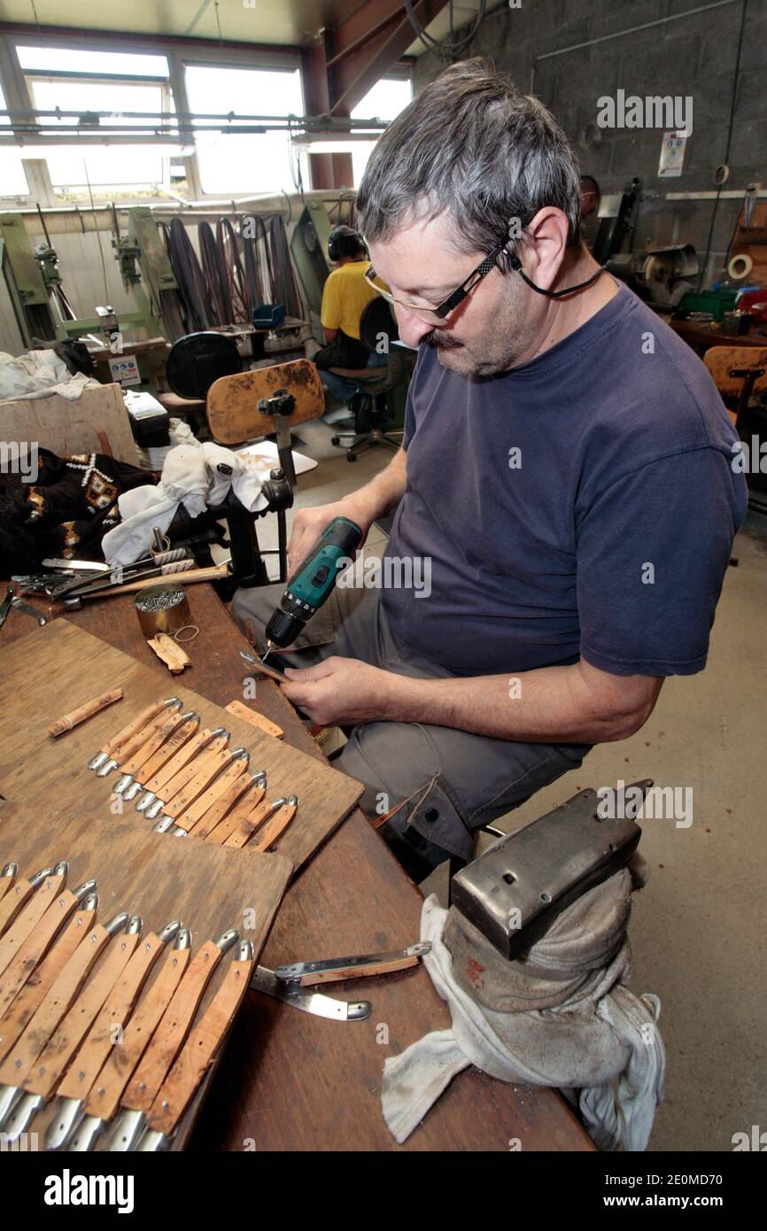 I lavoratori sono visti presso la fabbrica di coltelli 'la Forge de Laguiole' il 19 settembre 2012 a Laguiole, Francia centrale. I residenti di Laguiole, un villaggio sinonimo dei coltelli più famosi della Francia, hanno simbolicamente 'senza nome' la loro casa in una protesta per aver perso il controllo sul nome. Gli abitanti del villaggio sono furiosi che il nome Laguiole è passato nelle mani di un imprenditore che gli permette di essere utilizzato per vendere coltelli made-in-China e barbecue. Foto di Pascal Parrot/ABACAPRESS.COM Foto Stock