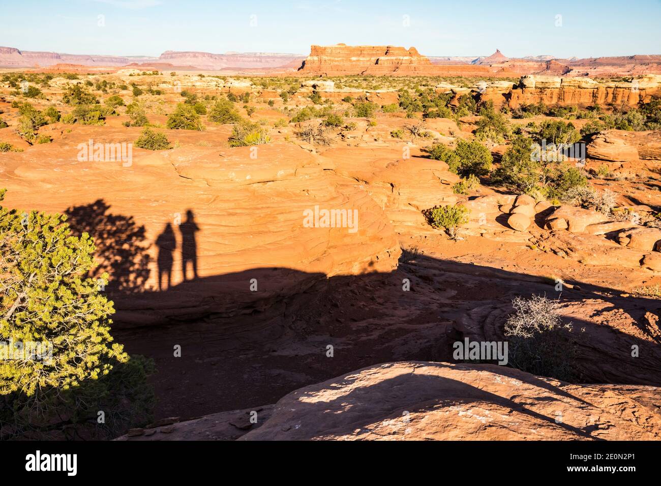 Un fotografo e compagni appaiono ombre su una roccia all'interno della sua fotografia del paesaggio nel Canyonlands National Park, Utah (The Needles District Foto Stock