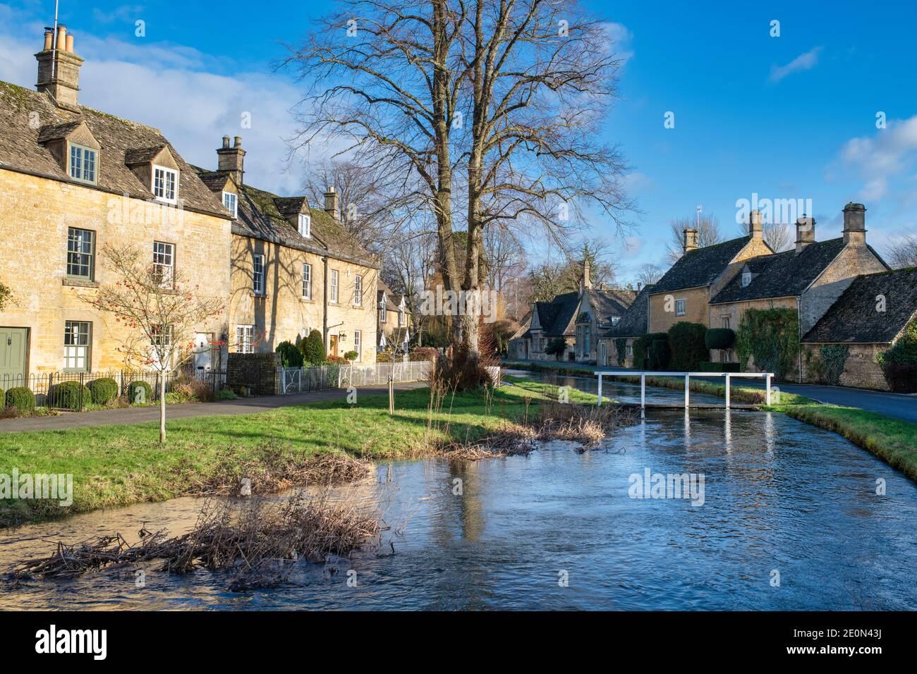 Fiume occhio alti livelli d'acqua nel villaggio di cotswold di macellazione inferiore la vigilia di Natale. Lower Slaughter, Cotswolds, Gloucestershire, Inghilterra Foto Stock