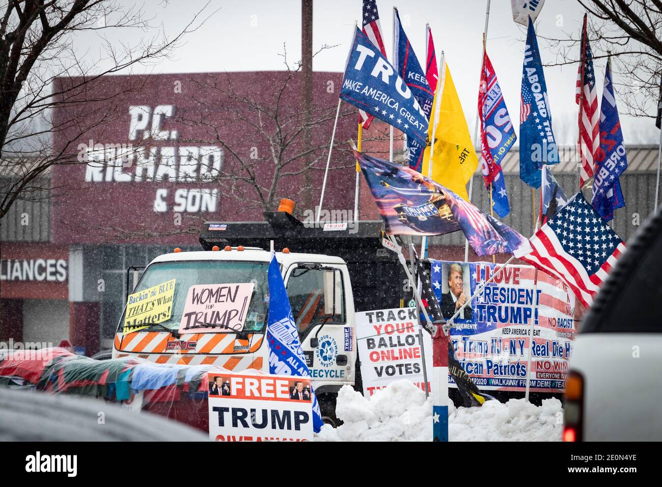 Un camion decorato da Trump con bandiere e bandiere pro-Trump e anti-Biden, parcheggiato a bordo strada nella neve invernale molto tempo dopo l'elezione di Trump lo Foto Stock