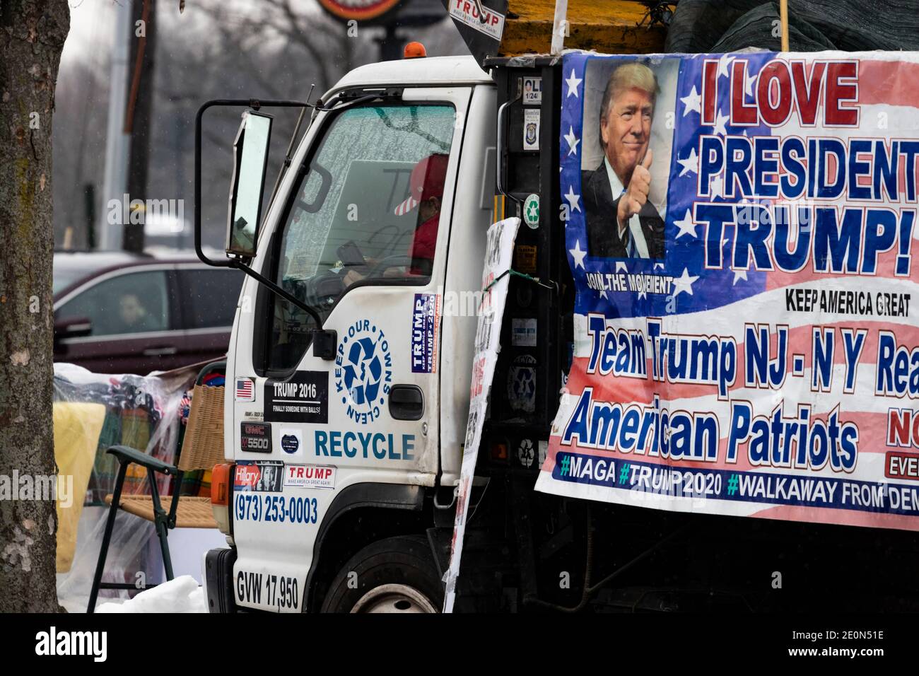 Molto tempo dopo che Donald Trump ha perso le elezioni del 2020, un sostenitore decora il suo camion con bandiere pro-Trump e anti-Biden e si siede a bordo strada in inverno Foto Stock