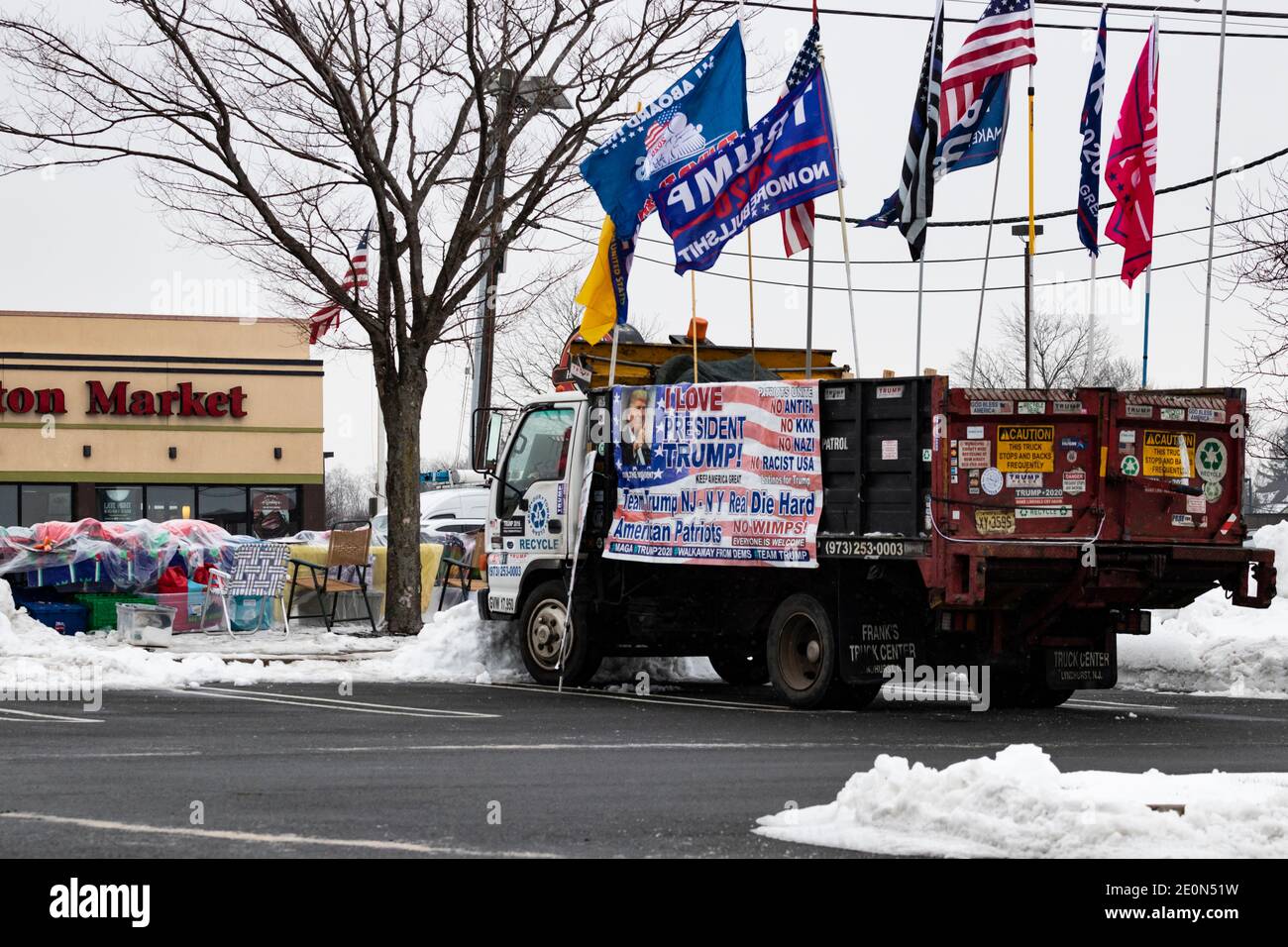 Molto tempo dopo che Donald Trump ha perso le elezioni del 2020, un sostenitore decora il suo camion con bandiere e bandiere pro-Trump e anti-Biden e si siede a lato strada Foto Stock