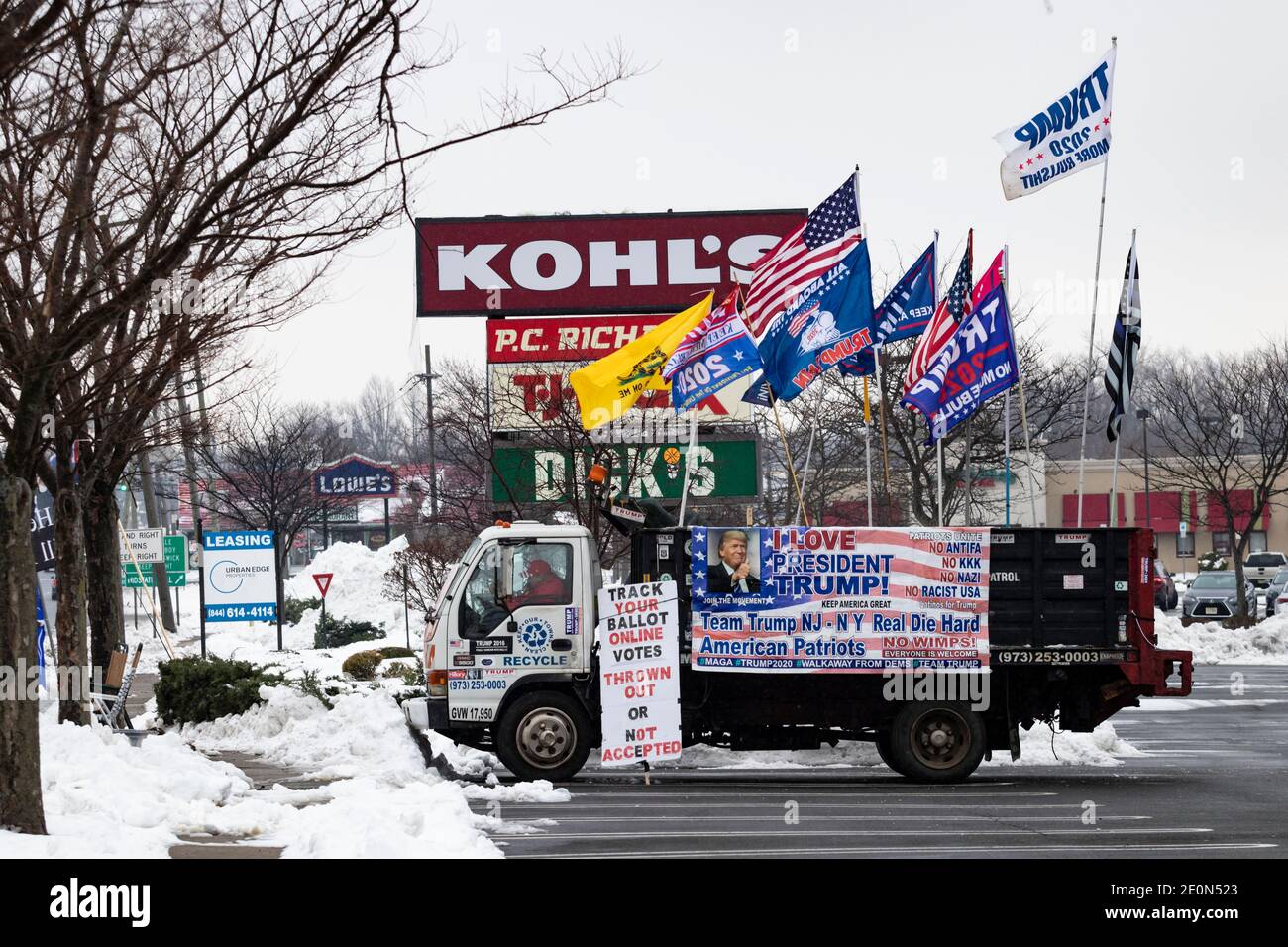 Molto tempo dopo che Donald Trump ha perso le elezioni del 2020, un sostenitore decora il suo camion con bandiere pro-Trump e anti-Biden e siede sulla strada nella neve Foto Stock