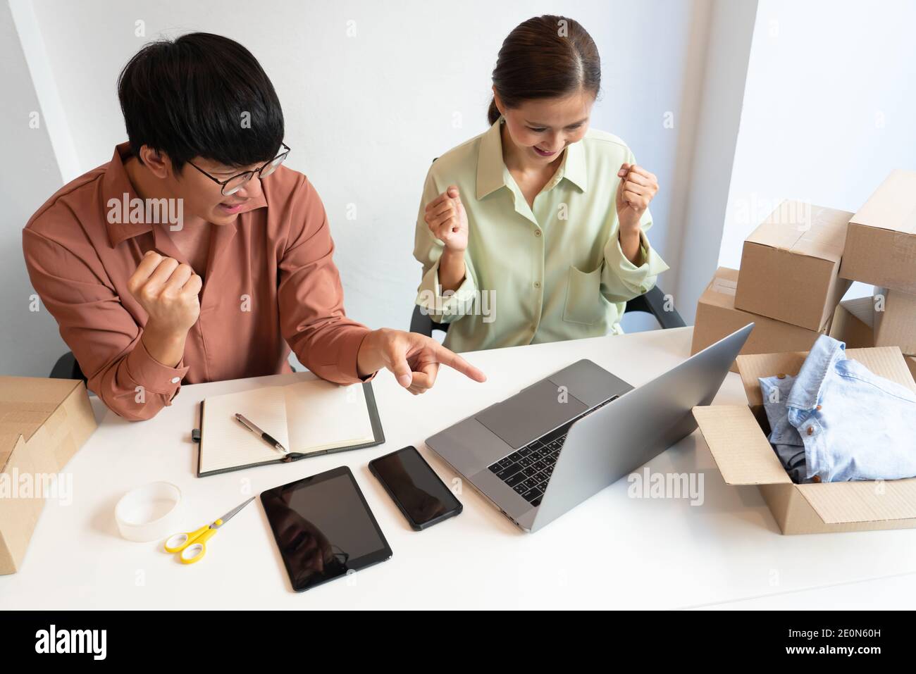 Il proprietario asiatico della coppia di affari che lavora a casa con la scatola di imballaggio del loro deposito in linea prepara per trasportare i prodotti ai clienti, vita di generazione dell'alfa sty Foto Stock