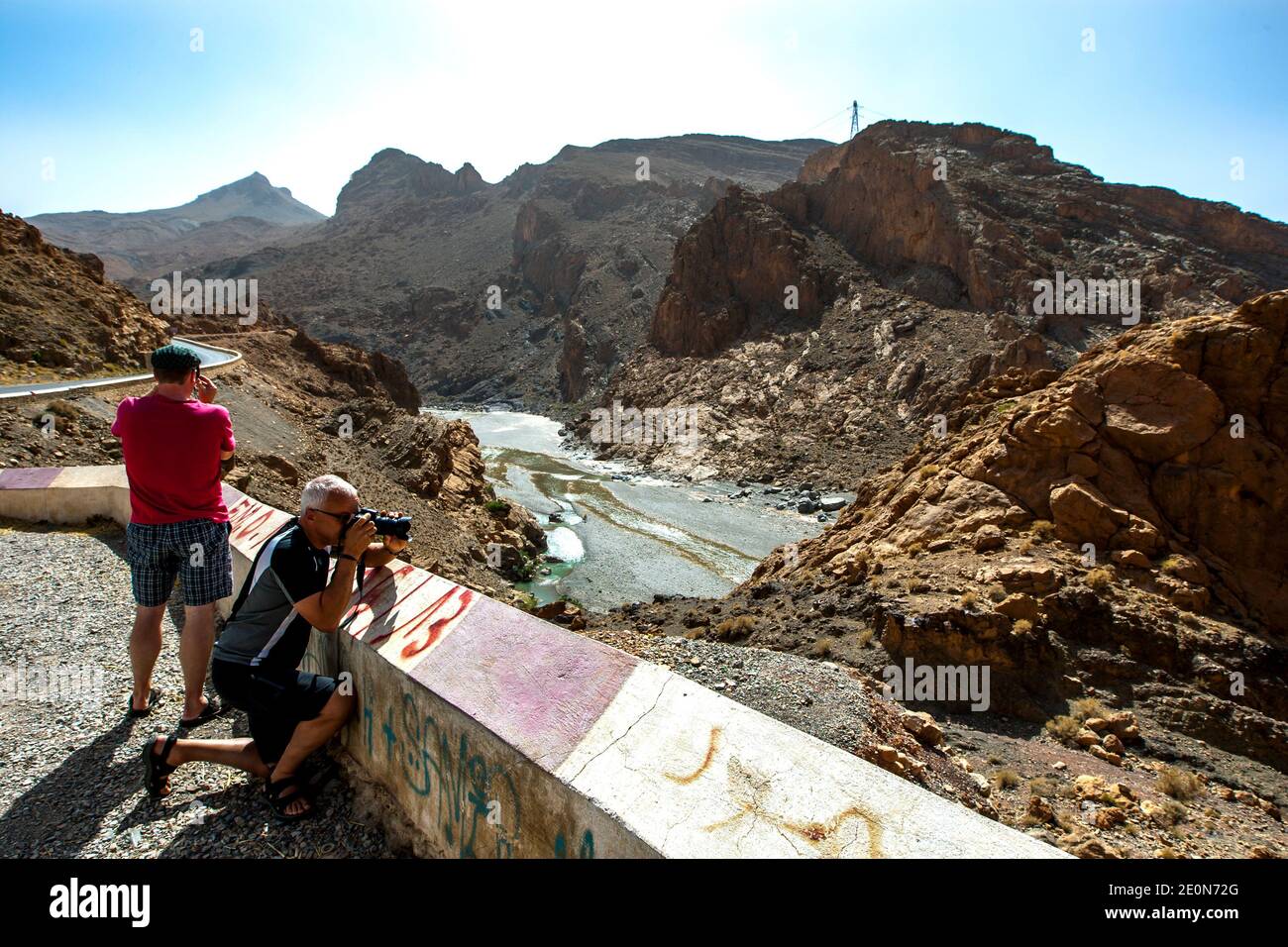 Turisti stranieri che fotografano il fiume Ziz nella valle di Ziz nelle montagne dell'Alto Atlante del Marocco. Foto Stock