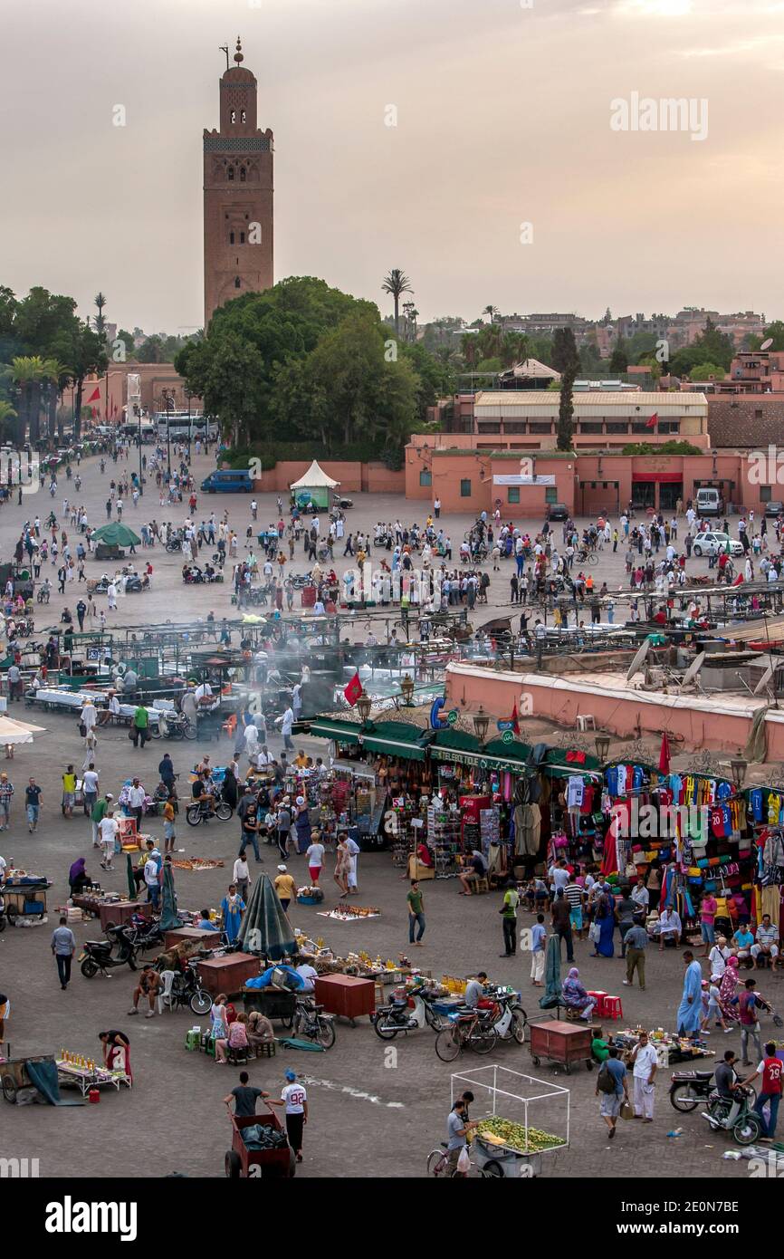 Visitatori e venditori affollano la colorata Djemaa el-Fna, la piazza principale della medina di Marrakech in Marocco. Marrakech è stata fondata nel 1062. Foto Stock