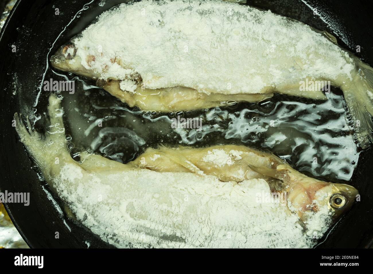 il pesce in pastella con crosta croccante viene fritto in farina di pangrattato e cotto in una padella con olio. Ricetta per la cucina tradizionale di pesce fritto Foto Stock