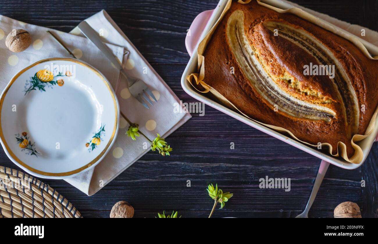 Pan di Spagna di banana rudy con piatto vintage, spuntino sano su tavola nera rustica. Vista dall'alto. Foto Stock