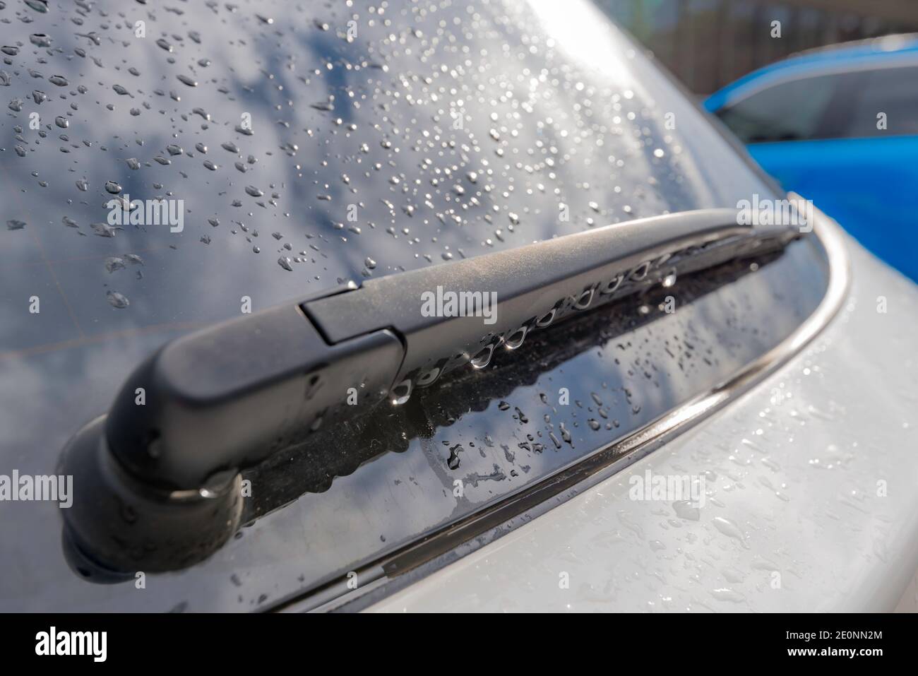 Nuvole bianche e cielo blu che si riflettono da una pioggia abbassare il finestrino posteriore dell'auto anonimo coperto e una parte posteriore nera tergicristallo Foto Stock Nuvole bianche e cielo blu che si riflettono da una pioggia abbassare il finestrino posteriore dell'auto anonimo coperto e una parte posteriore nera tergicristallo Foto Stock