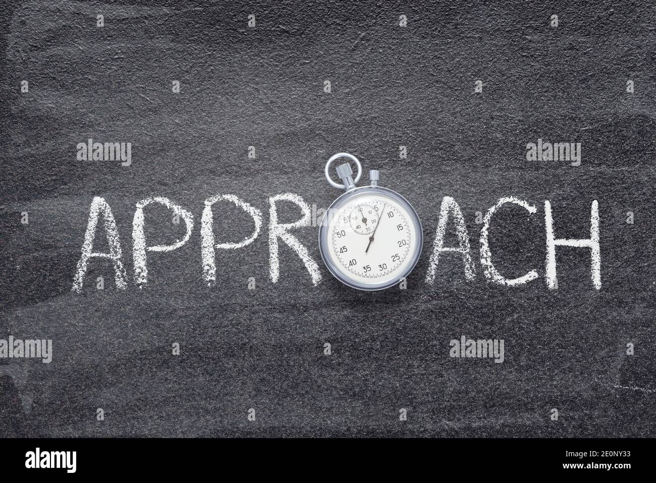 parola di avvicinamento scritta a mano sulla lavagna con cronometro vintage preciso utilizzato Invece di o Foto Stock