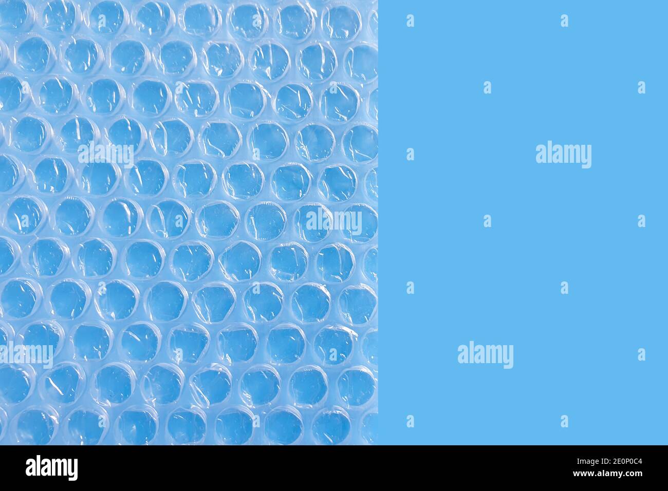 Imballaggio a bolle d'aria o pellicola cuscino d'aria su sfondo blu. Foto Stock