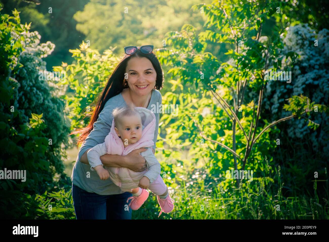 madre con figlia nel giardino di primavera durante la fioritura Foto Stock