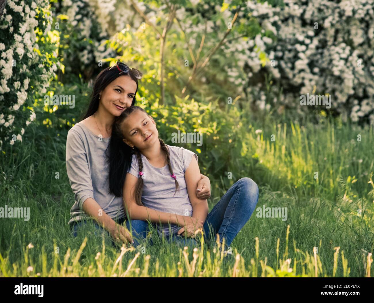 madre con figlia nel giardino di primavera durante la fioritura Foto Stock