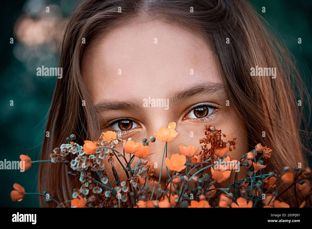 occhi marroni di una giovane ragazza primo piano per i fiori Foto Stock