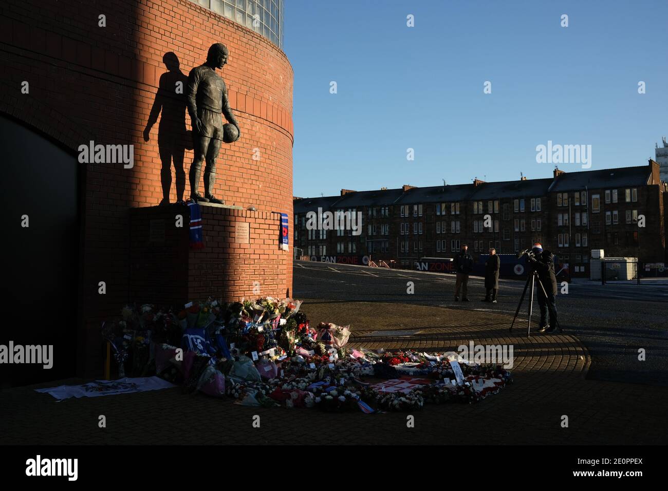 Glasgow, Regno Unito, 2 gennaio 2021. I sostenitori del Rangers Football Club lasciano fiori e sciarpe in un memoriale (raffigurante il calciatore dei Rangers John Greig) a quei 66 tifosi che hanno perso la vita nel disastro dello Ibrox Stadium, avvenuto 50 anni fa oggi il 2 gennaio 1971. L'anniversario cade nel giorno in cui il Rangers FC gioca i loro rivali Celtic FC, a casa, in una partita di campionato. Foto: Jeremy Sutton-Hibbert/Alamy Live News. Foto Stock