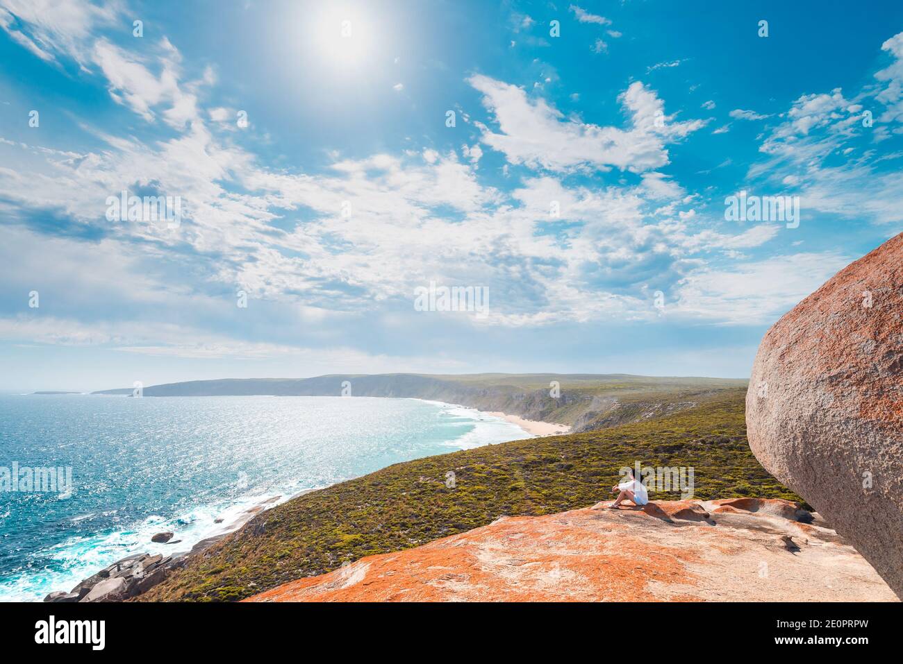 Donna seduta sul bordo della scogliera a Remarkable Rocks su Kangaroo Island, Australia del Sud Foto Stock