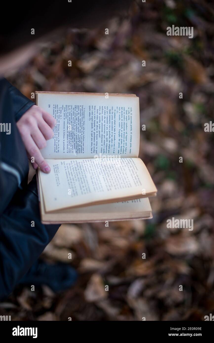 il ragazzino legge un libro - piacevole da leggere in aria fresca Foto Stock