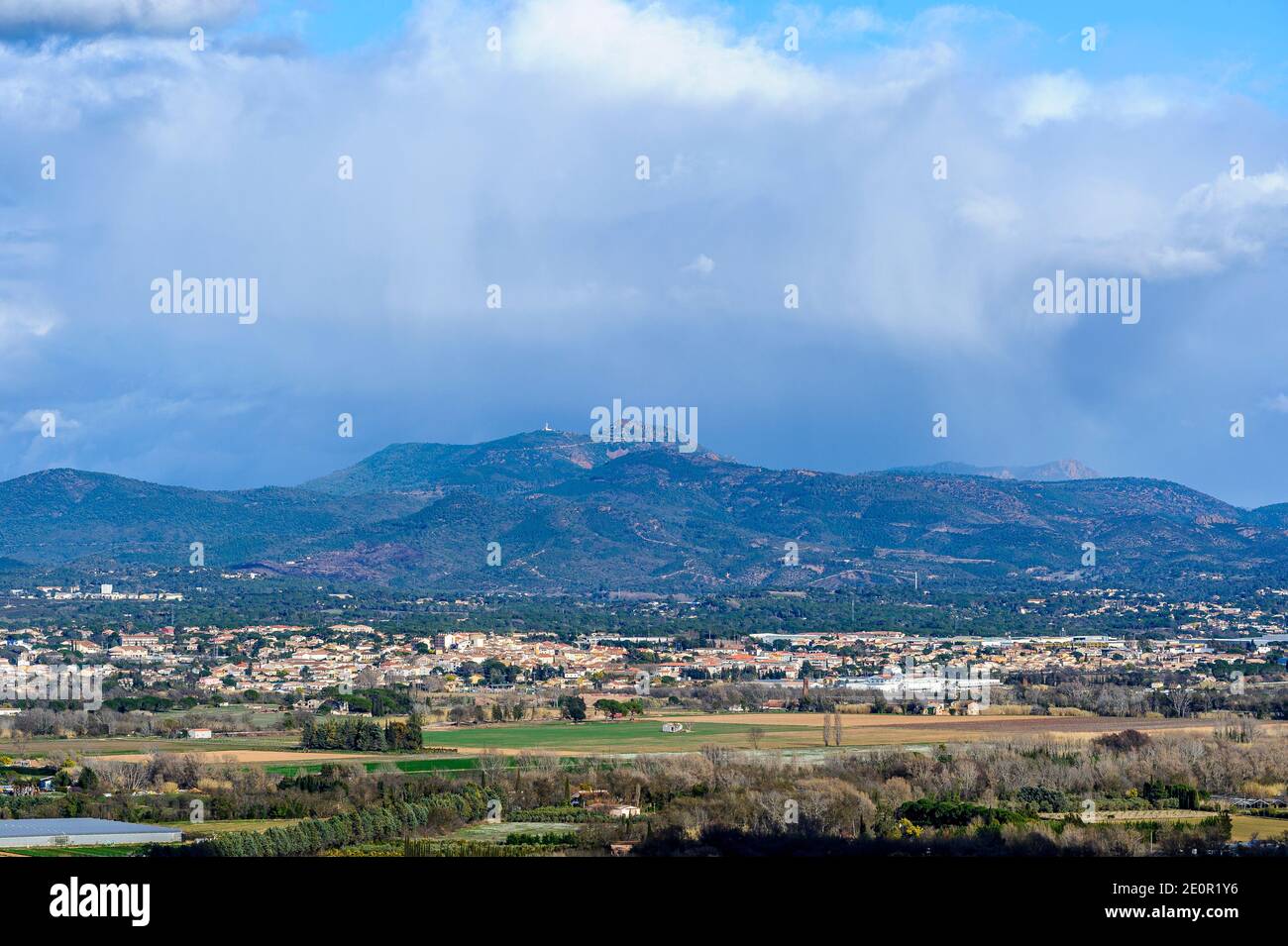 Paesaggio invernale dell'entroterra provenzale. Il villaggio di Roquebrune-sur-Argens con le montagne Esterel sullo sfondo. Un cielo nuvoloso. Foto Stock