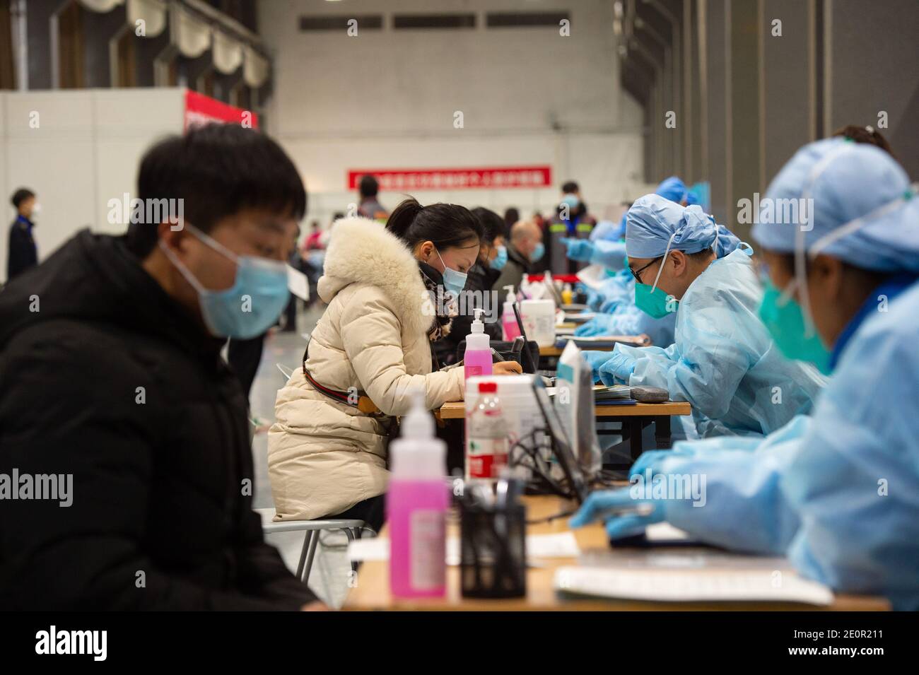 (210102) -- PECHINO, 2 gennaio 2021 (Xinhua) -- le persone compilano il modulo di consenso informato prima della vaccinazione COVID-19 in un sito di vaccinazione temporanea a Pechino, capitale della Cina, 2 gennaio 2021. Pechino ha iniziato a somministrare vaccini COVID-19 tra gruppi specifici di persone con maggiori rischi di infezione. Nove gruppi di persone di età compresa tra i 18 e i 59 anni riceveranno il vaccino prima del Festival di primavera del 2021, che cade il 12 febbraio. Tra questi figurano gli ispettori doganali di prima linea delle merci importate della catena del freddo e il personale che opera nel settore dei trasporti esteri e nazionali. (Xinhua/Chen Zhonghao) Foto Stock