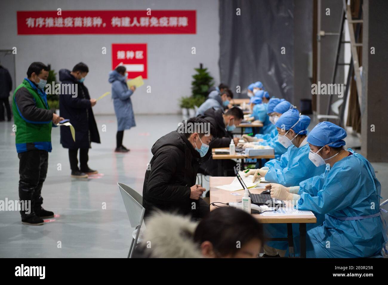 (210102) -- PECHINO, 2 gennaio 2021 (Xinhua) -- le persone compilano il modulo di consenso informato prima della vaccinazione COVID-19 in un sito di vaccinazione temporanea a Pechino, capitale della Cina, 2 gennaio 2021. Pechino ha iniziato a somministrare vaccini COVID-19 tra gruppi specifici di persone con maggiori rischi di infezione. Nove gruppi di persone di età compresa tra i 18 e i 59 anni riceveranno il vaccino prima del Festival di primavera del 2021, che cade il 12 febbraio. Tra questi figurano gli ispettori doganali di prima linea delle merci importate della catena del freddo e il personale che opera nel settore dei trasporti esteri e nazionali. (Xinhua/Chen Zhonghao) Foto Stock