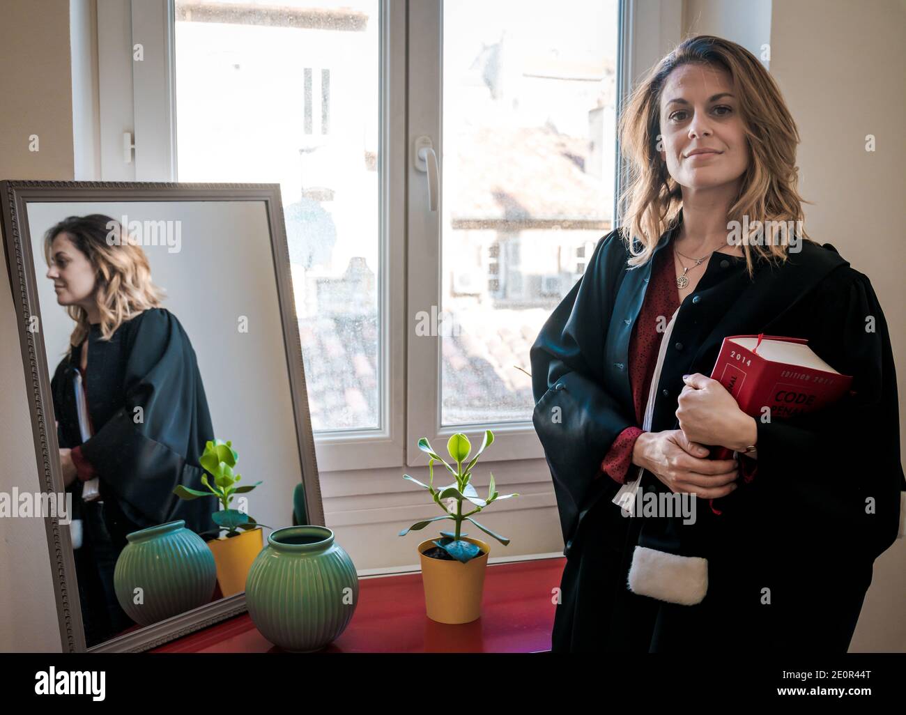 Avvocato francese donna in piedi e tenendo libro di legge rosso Foto Stock