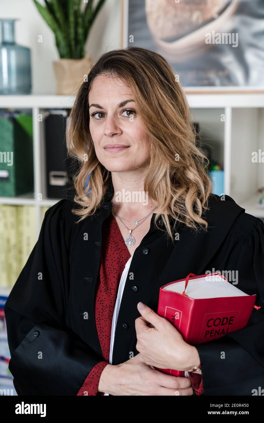 Avvocato donna in possesso di libro di legge rosso - giovane francese bello donna avvocato Foto Stock