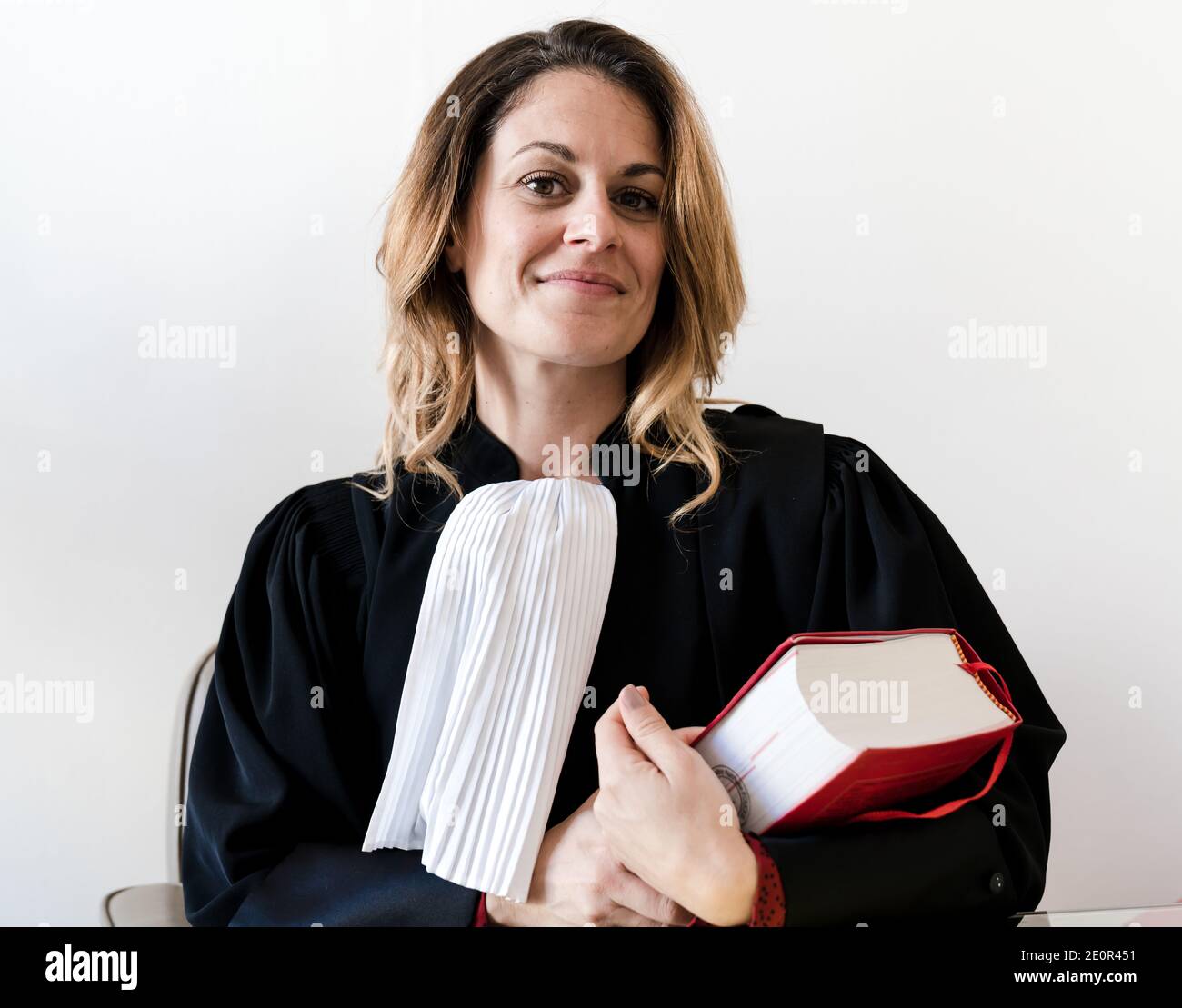 Avvocato donna in possesso di libro di legge rosso - giovane francese bello donna avvocato Foto Stock