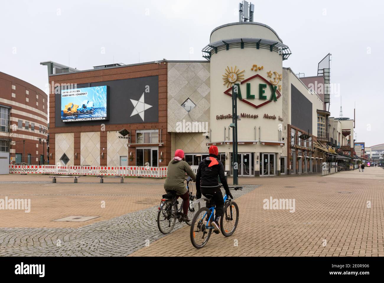 Centro, Oberhausen, NRW, Germania. 02 gennaio 2021. Due ciclisti dove migliaia di persone normalmente passeggiano, pieni di borse per lo shopping. Il più grande centro commerciale della Germania e i ristoranti, i caffè e i divertimenti circostanti appaiono sgarbati e desertati, le entrate sono chiuse e chiuse. Il popolare centro commerciale con 125.000 m² di spazio commerciale e l'intera area all'aperto sarebbe normalmente un grande paradiso per gli acquirenti alla ricerca di occasioni nelle vendite di gennaio. Credit: Imageplotter/Alamy Live News Foto Stock
