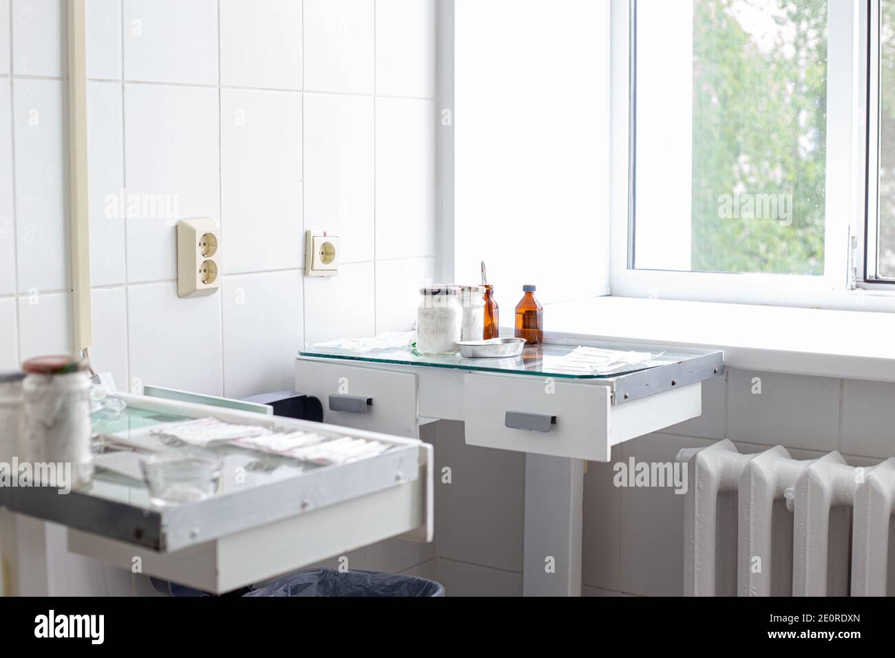 sala trattamento in ospedale, tavoli in vetro con strumenti medici, pulizia e sterilità Foto Stock