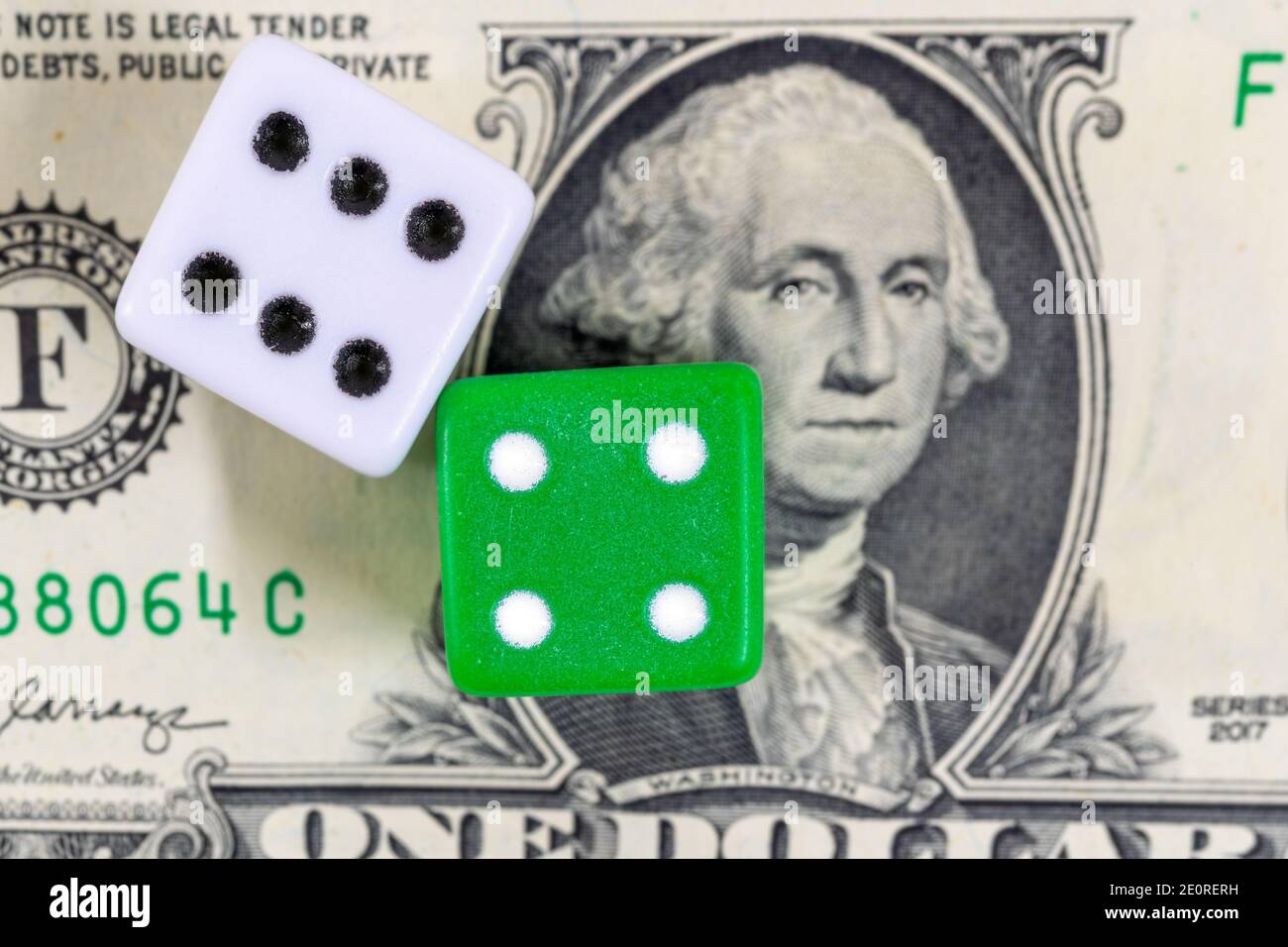 Dadi verdi e bianchi su un conto del dollaro, un concetto di gioco d'azzardo Foto Stock