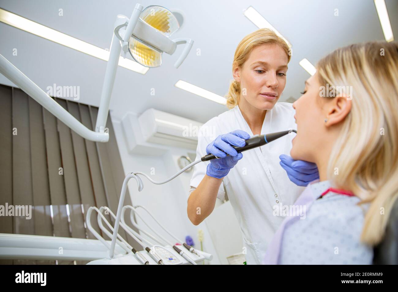 Medico di controllo uniforme fino femmina di denti del paziente in Clinica Dentale Foto Stock