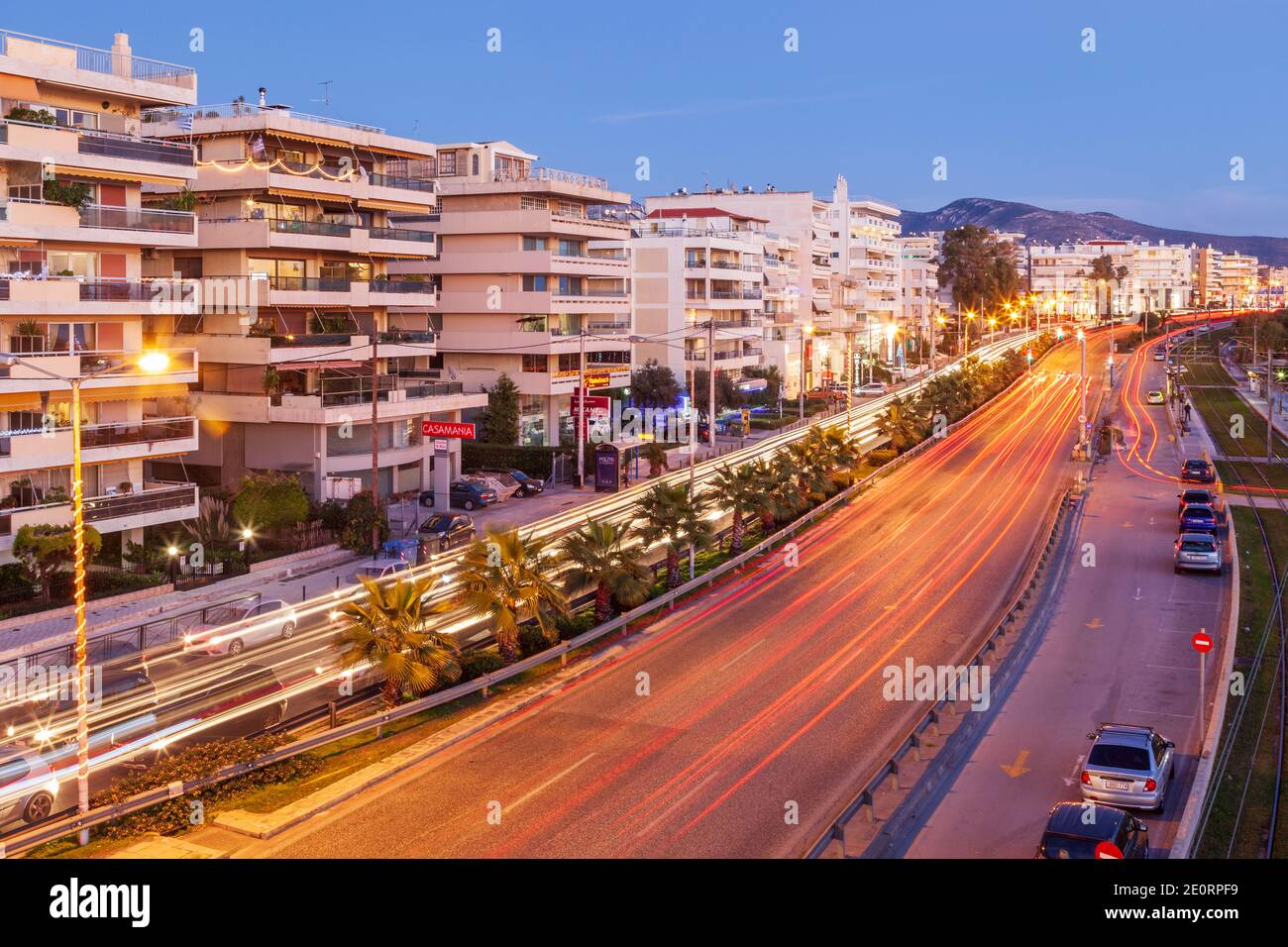 Ora blu al viale Posidonos, il viale costiero principale di Atene, Grecia, durante il tramonto nel giorno di Capodanno. Foto Stock