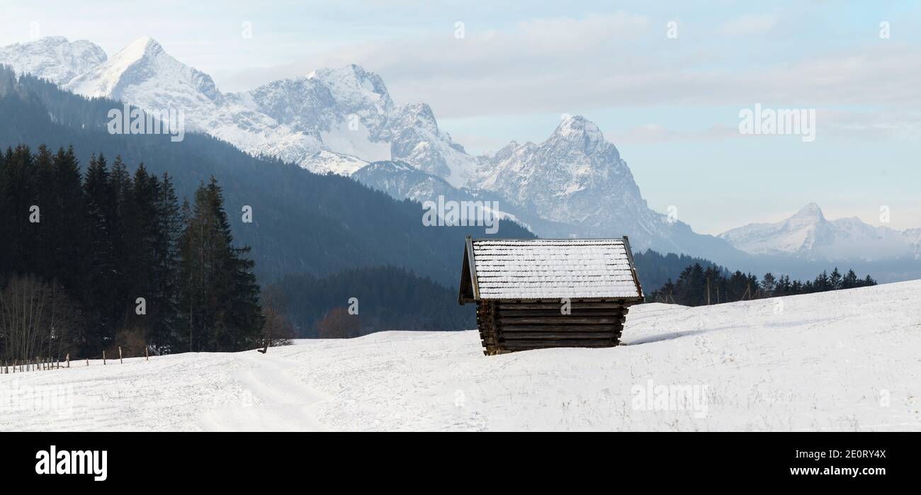 Remota capanna di legno di fronte alle Alpi panorama - Zugspitze E Alpspitze Foto Stock