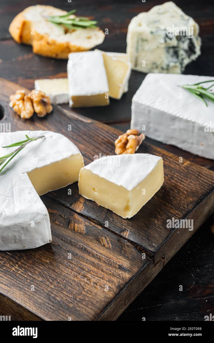 Piatto di antipasti con formaggio fresco, pane e olive, su fondo di legno scuro Foto Stock