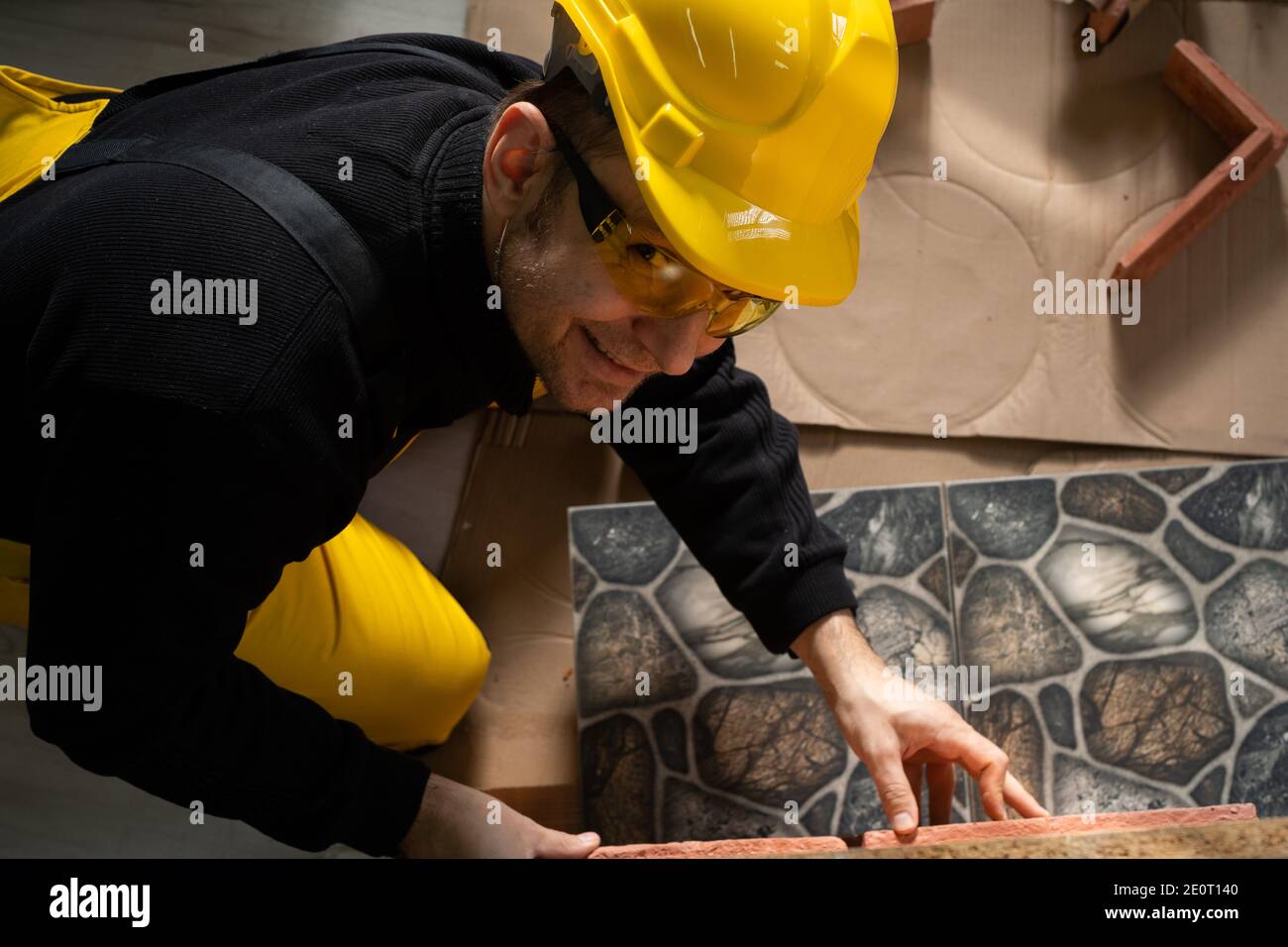 L'operatore manuale tenta di una tessera di una tessera per valutare se si adatta esattamente insieme. Un dipendente vestito con tutti i dispositivi di protezione individuale. Foto Stock