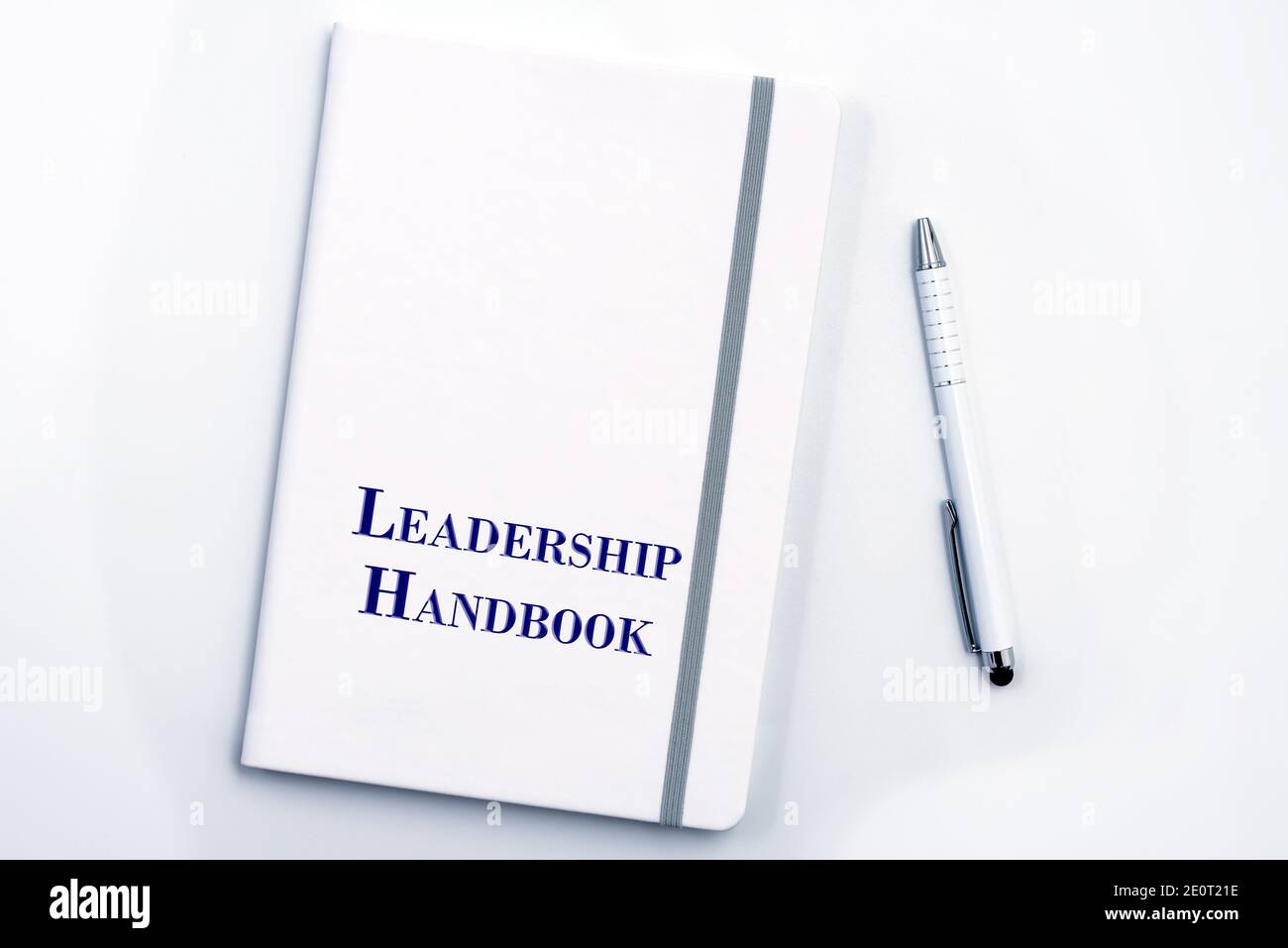 White Leadership Manuale o manuale con penna bianca sulla superficie bianca del tavolo - la politica di gestione del personale, spiega gli obiettivi aziendali, i risultati, definisce Lea Foto Stock