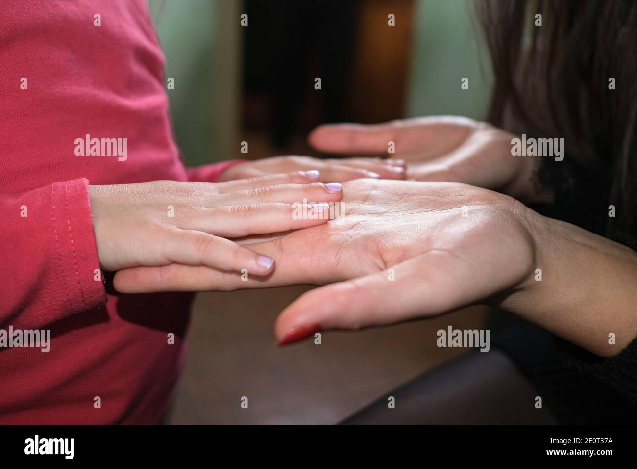 Le mani di madre e figlia si avvicinano mentre giocano a casa, in famiglia stile di vita Foto Stock
