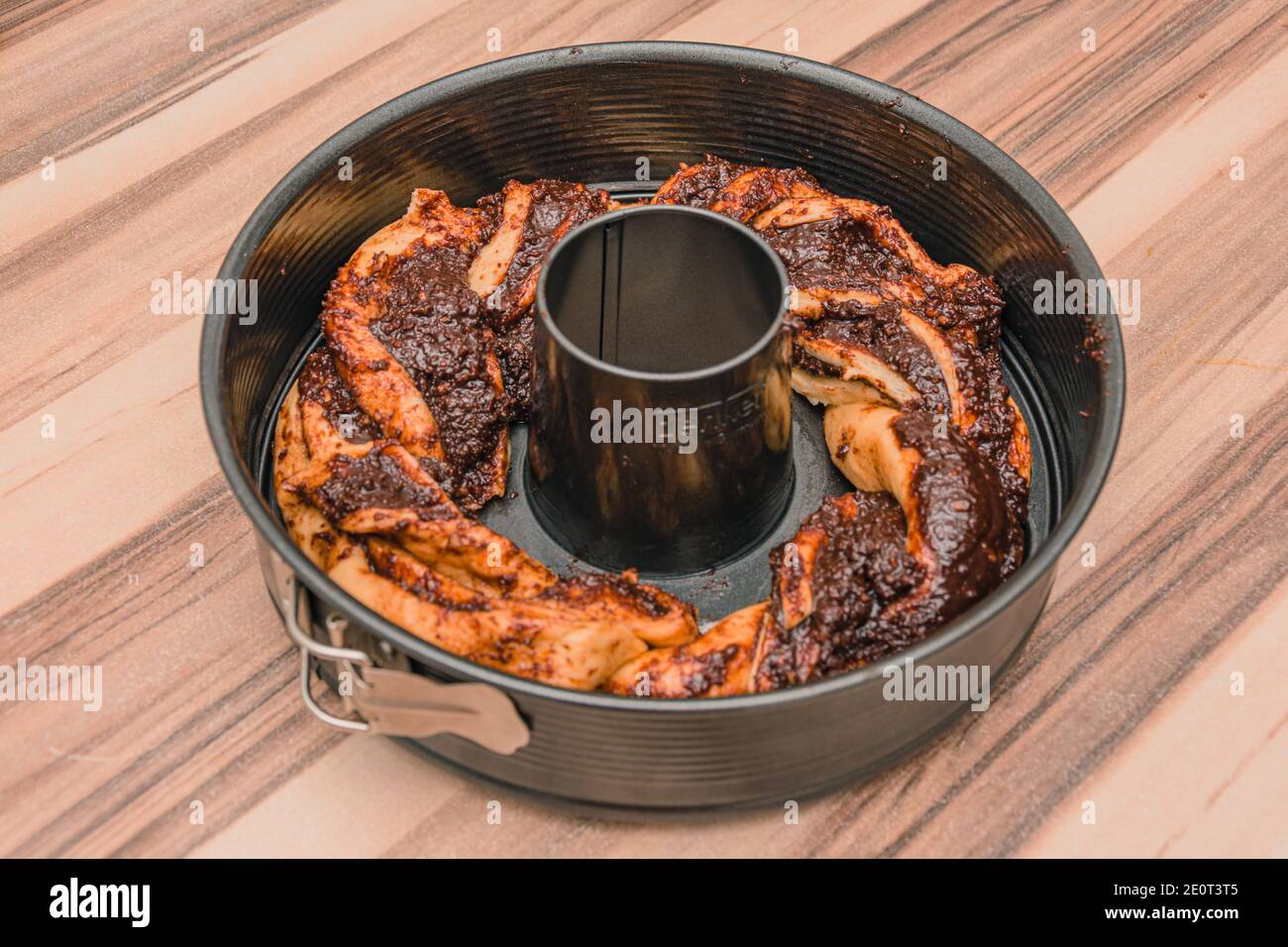 Vienna / Austria / 24 aprile 2020: Tondino grigio sul tavolo di legno con torta al cioccolato Foto Stock