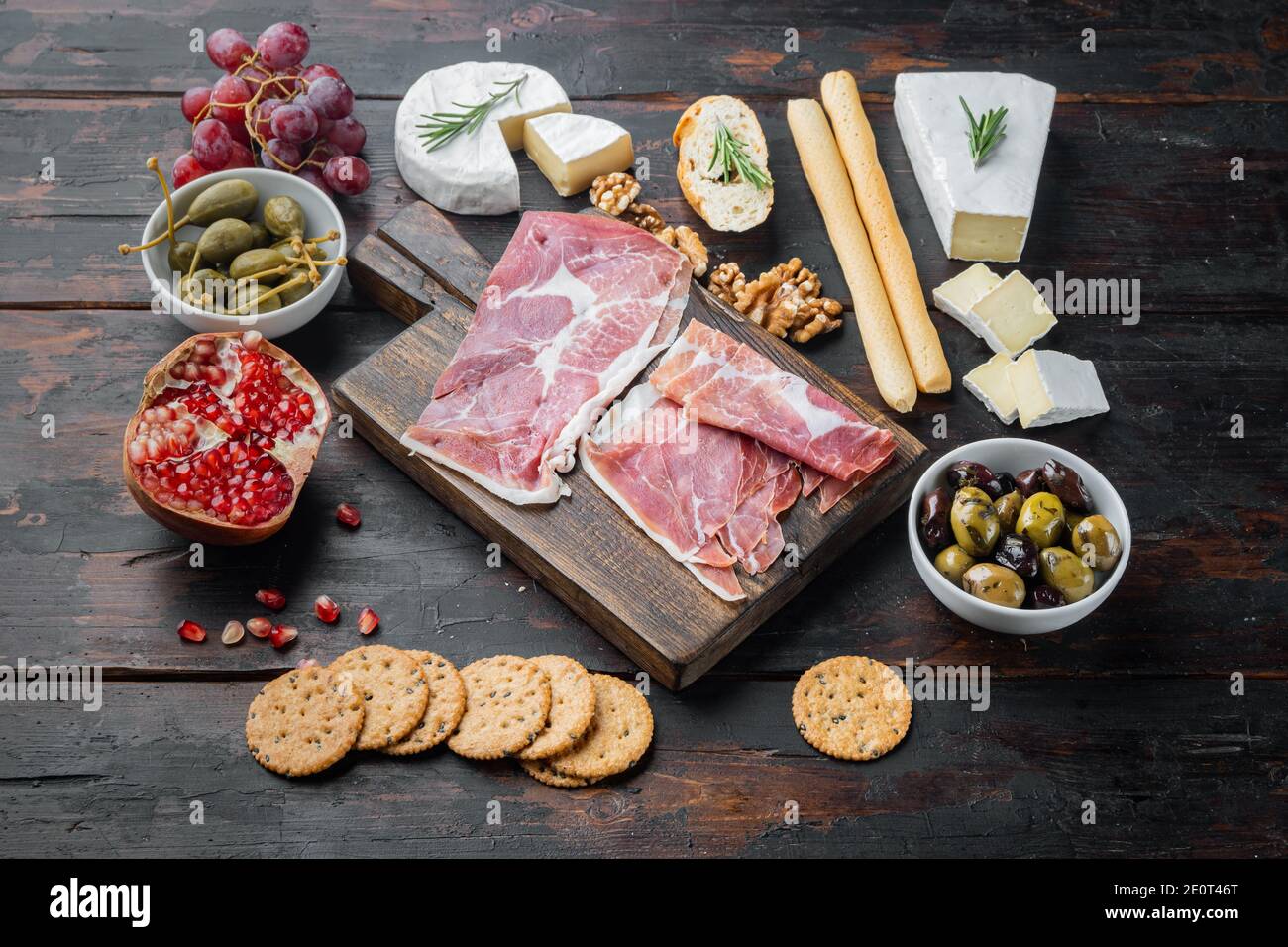 Tavolo di antipasti con diversi antipasti, su sfondo di legno scuro Foto Stock