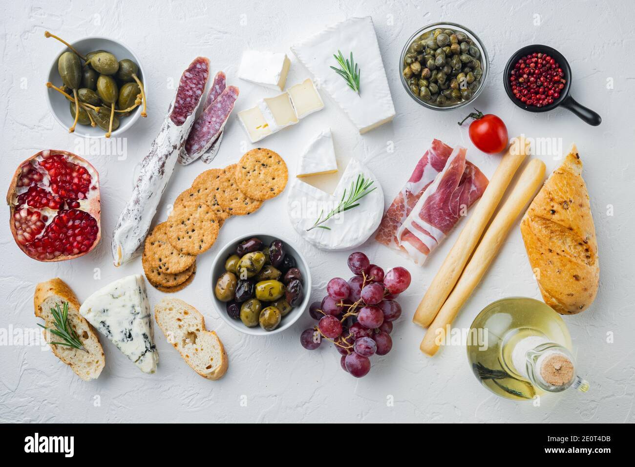 Tavolo per antipasti con diversi antipasti, su sfondo bianco, piatto Foto Stock