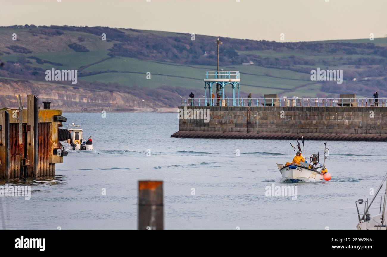 Piccola imbarcazione da pesca che ritorna al porto di Weymouth, Dorset, Regno Unito, il 2 gennaio 2021 Foto Stock