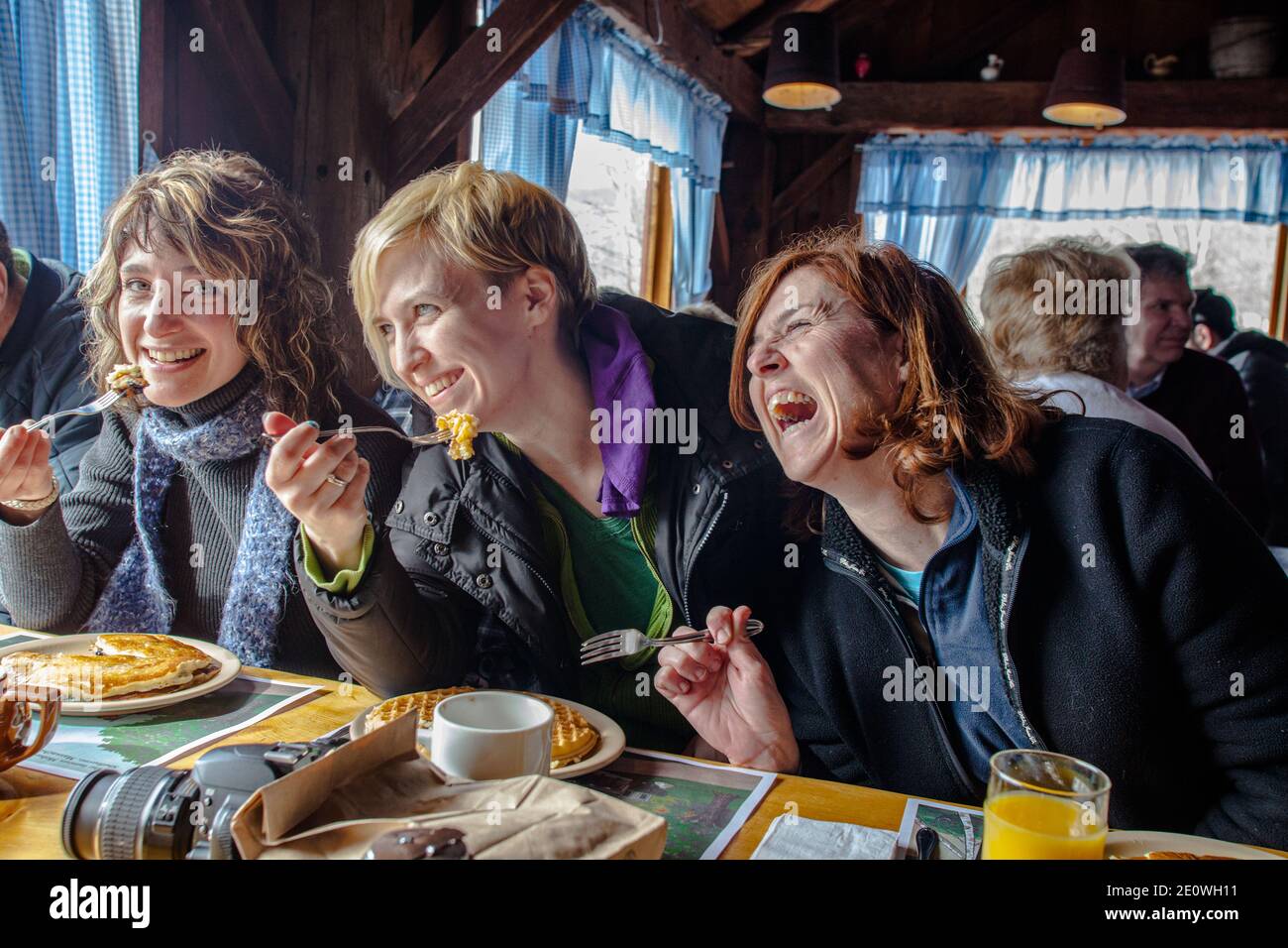 Tre donne che ridono a una barzelletta e si divertono molto nella Sugar House di Gould a Shelburne Falls, Massachusetts Foto Stock