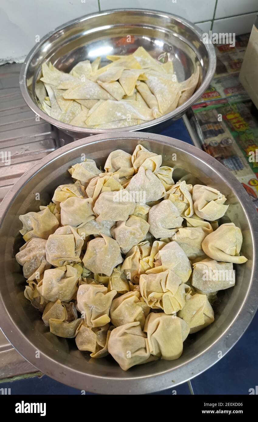 Cuocete gli gnocchi di maiale in un recipiente di preparazione degli alimenti in acciaio inossidabile. Foto Stock