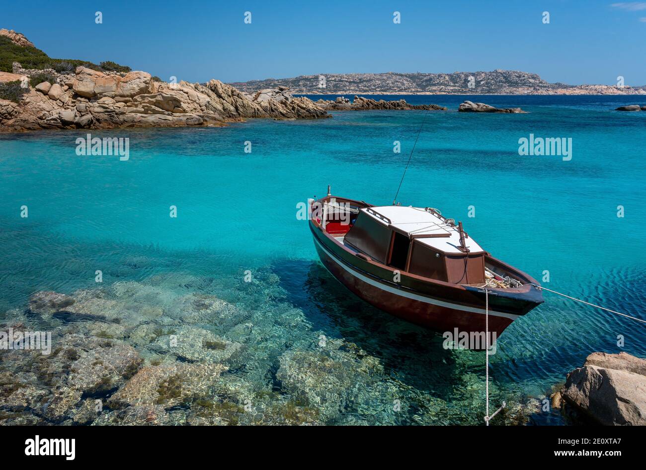 Piccola imbarcazione ancorata al mare turchese in Sardegna, Foto Stock